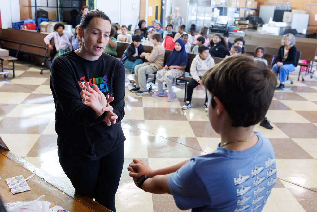 An adult teaches a student how to properly execute CPR.
