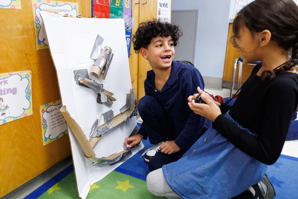 Students work together while timing marble runs during a STEM week activity.