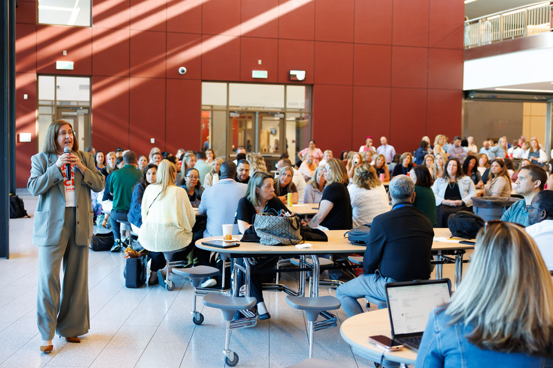 A woman address a crowd of people at a professional development event.