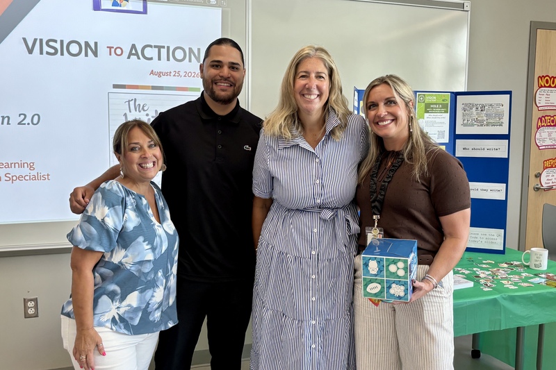 Four staff members stand together.