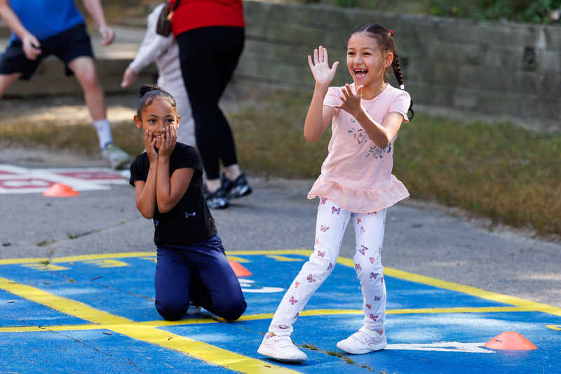 Two students smile while playing outdoors.