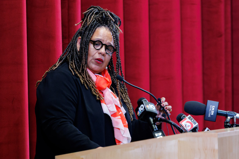A woman gives a speech at the podium.