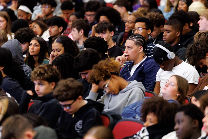 Students listen in the crowd.