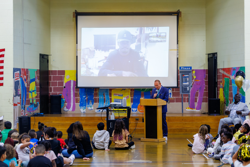Superintendent Brian E. Allen speaks at the podium during an assembly.
