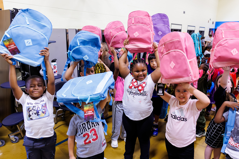 Students proudly display backpacks donated by New Orleans Saints cornerback and Worcester Public Schools alumnus Isaac Yiadom following a giveback event at Chandler Elementary Community School on Tuesday, October 7, 2025.