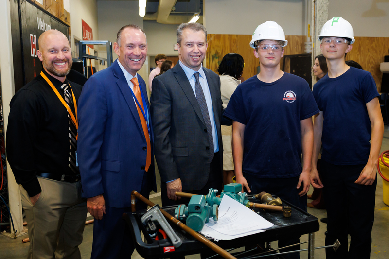 DESE Commissioner Pedro Martinez, WPS Superintendent Brian E. Allen and Principal Drew Weymouth stand with students in the HVAC program.