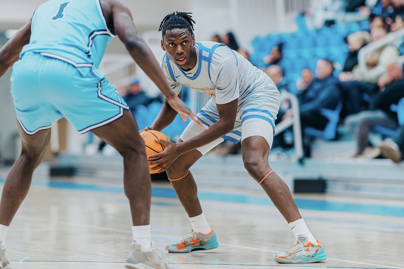 Joe Okla holds the ball at the top of the three-point line during a game for Worcester State University.