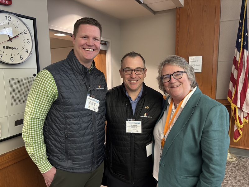 Three adults pose for a photo