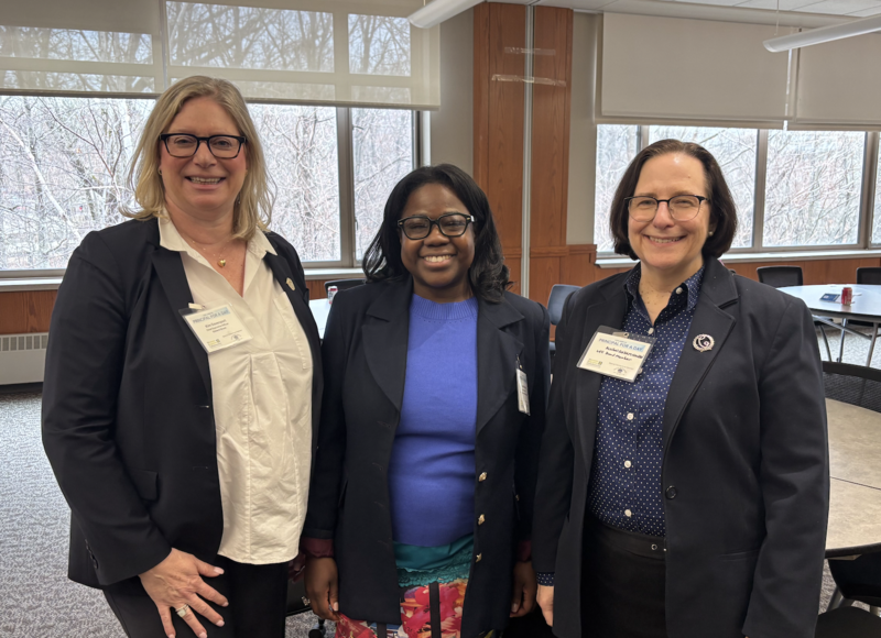 Three adults pose for a photo