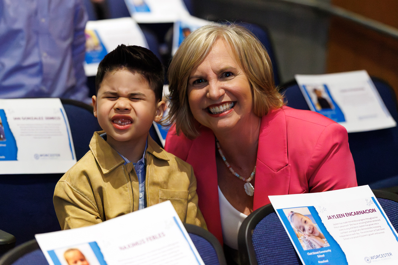 A student and teacher smile together for a photo.