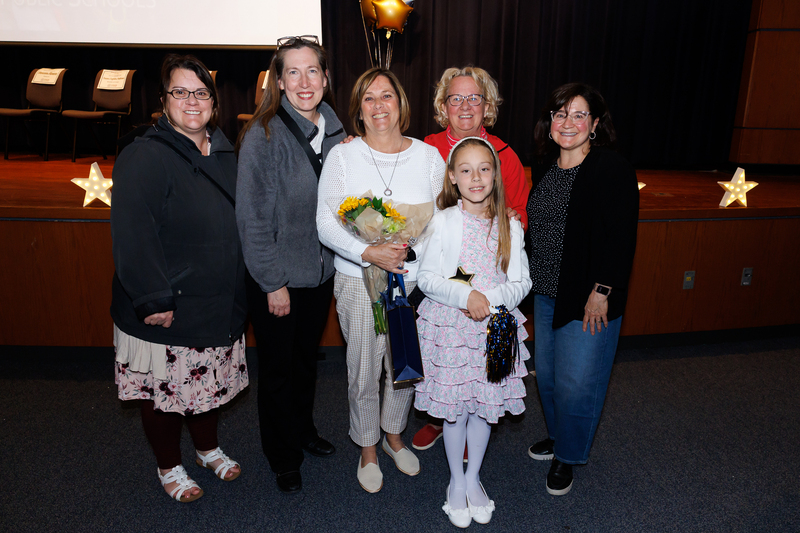 Six people stand together following an awards ceremony.