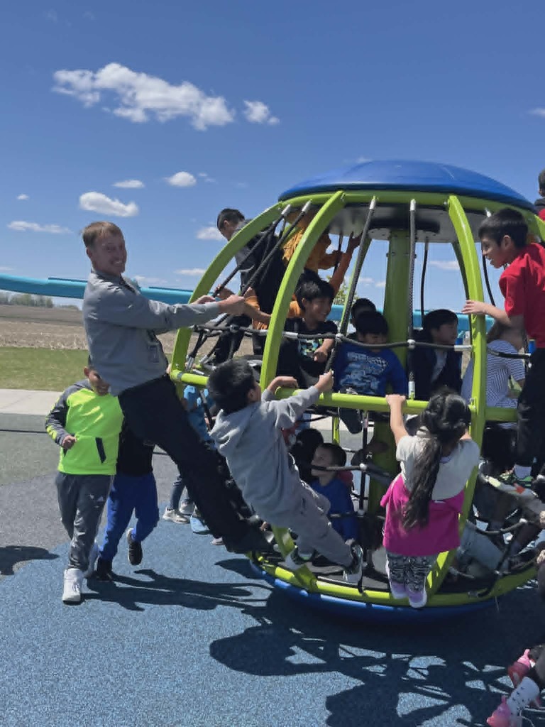 Students and Mr. Van Briesen on the Intermediate School Playground Equipment