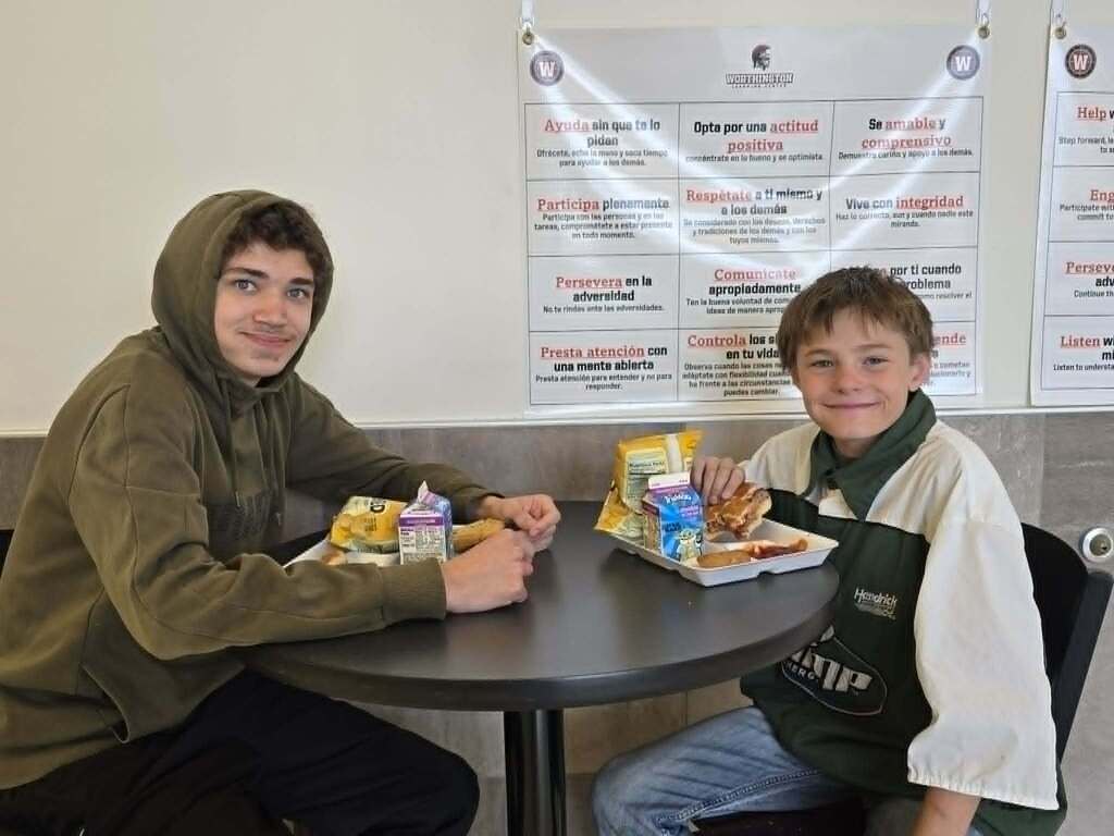 2 students sitting at the table eating lunch
