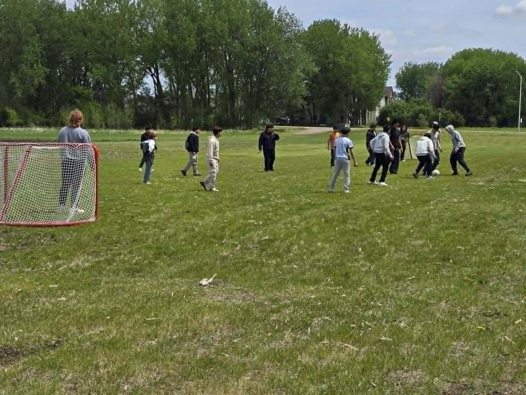 Students outside on the lawn playing soccer