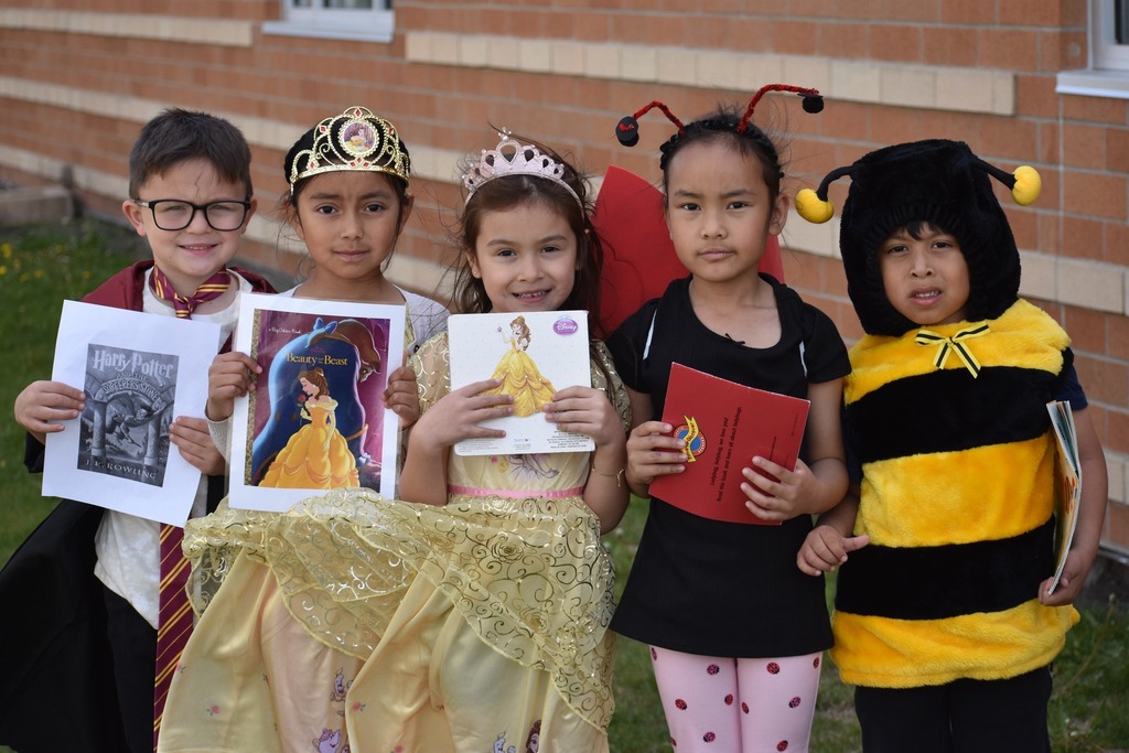 Kindergarten students dressed in costumes holding books