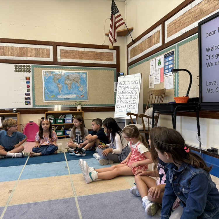 students sitting around the carpet during morning meeting