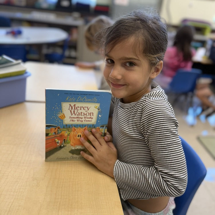 student posing with book