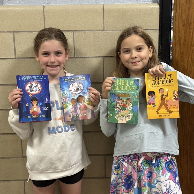 girls holding up new library books