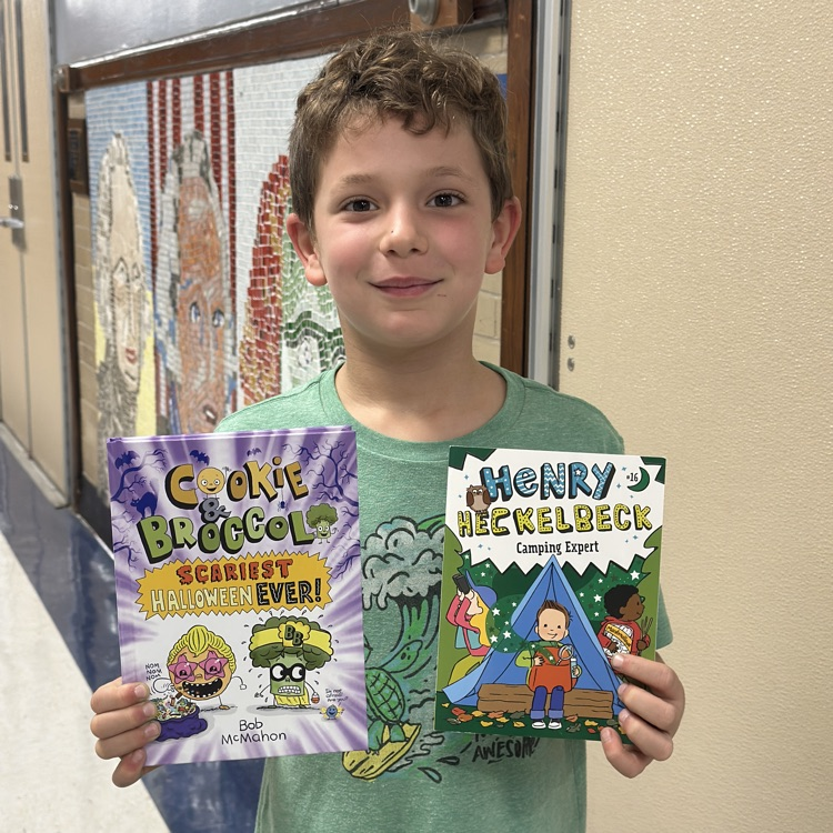 boy holding up new library books