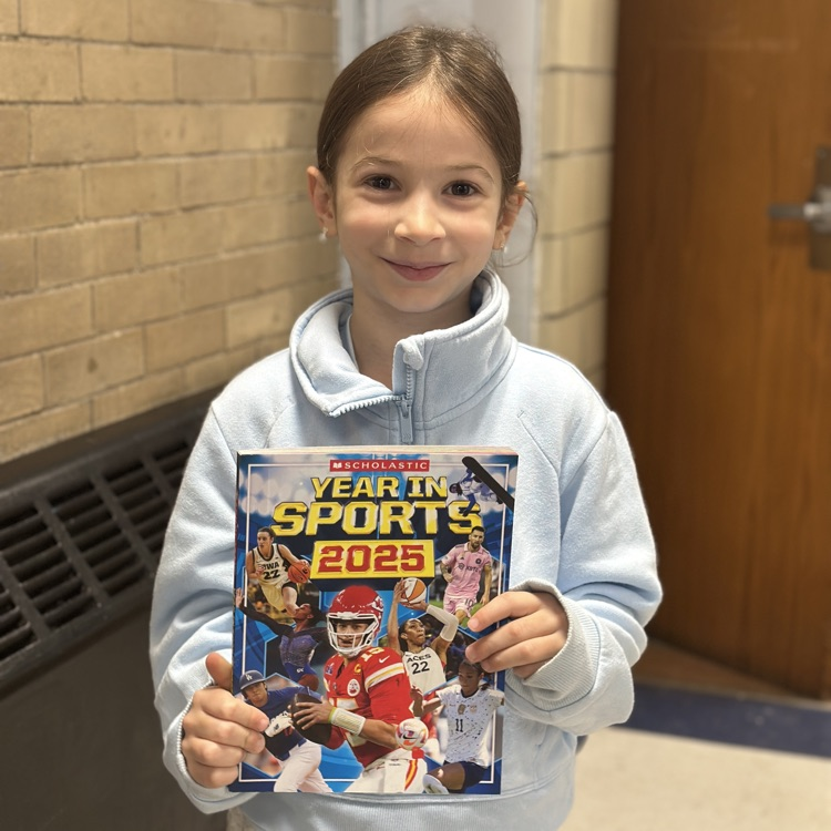 girl holding up new library book