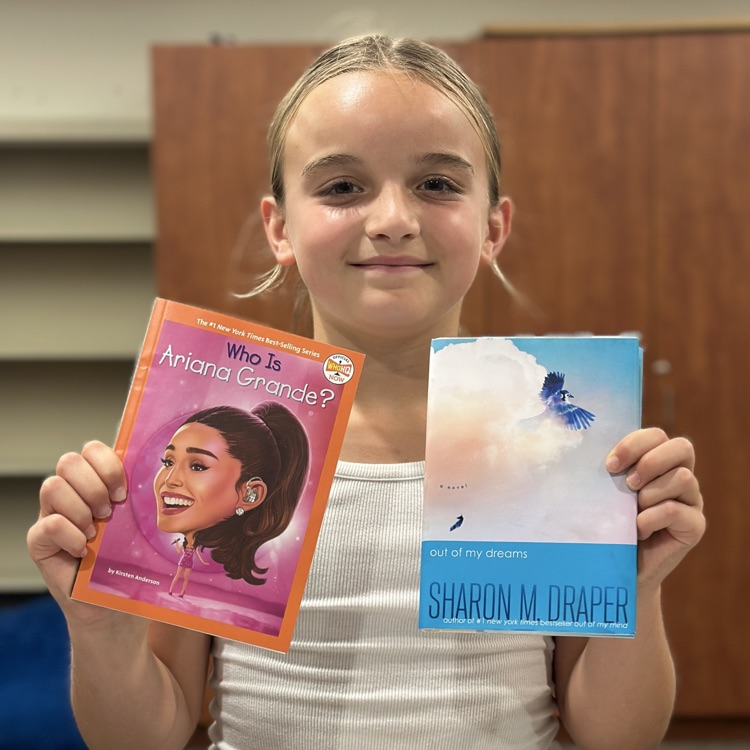 girl holding up new library books