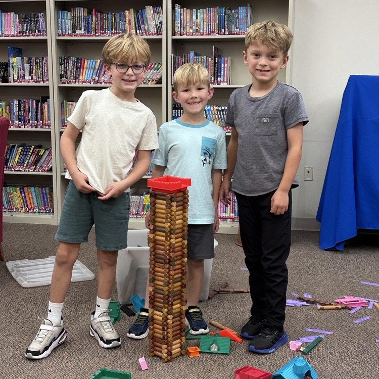 students standing behind their Lincoln log creation