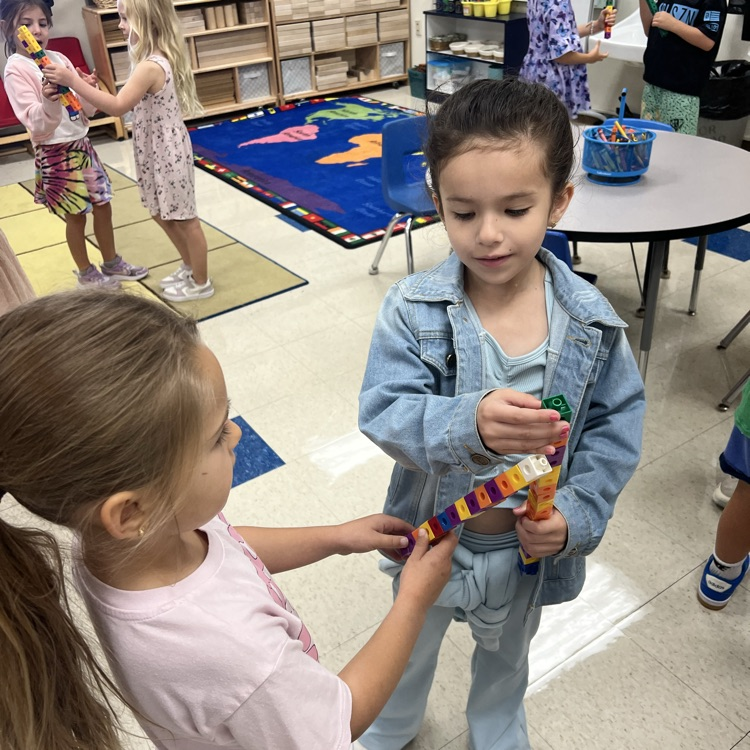 KRO compared the size of their connecting cube towers by using math vocabulary.