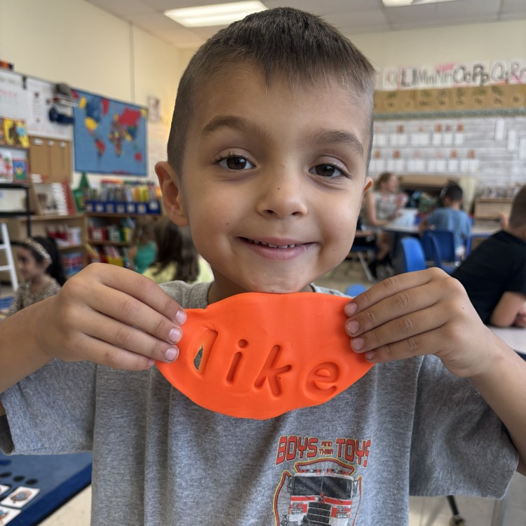 Little boy wrote the word like in Playdoh 