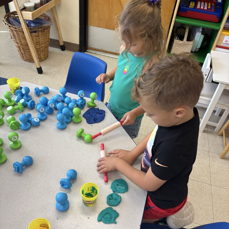 children playing with letter stampers