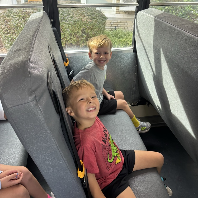 two boys sitting on a bus