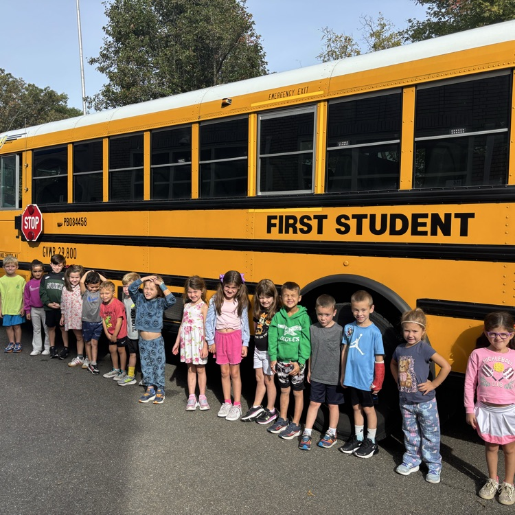 class standing in front of the bus