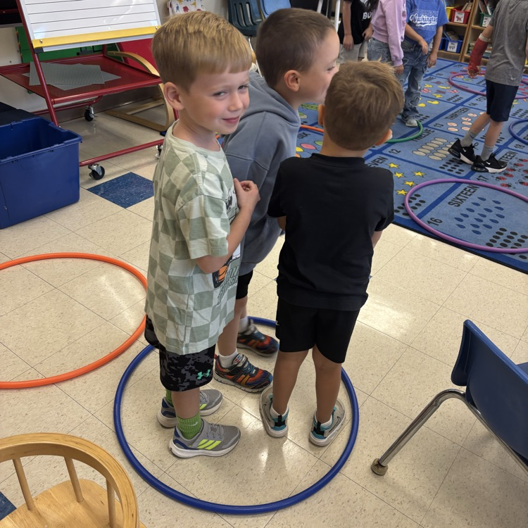 children standing in a hula hoop