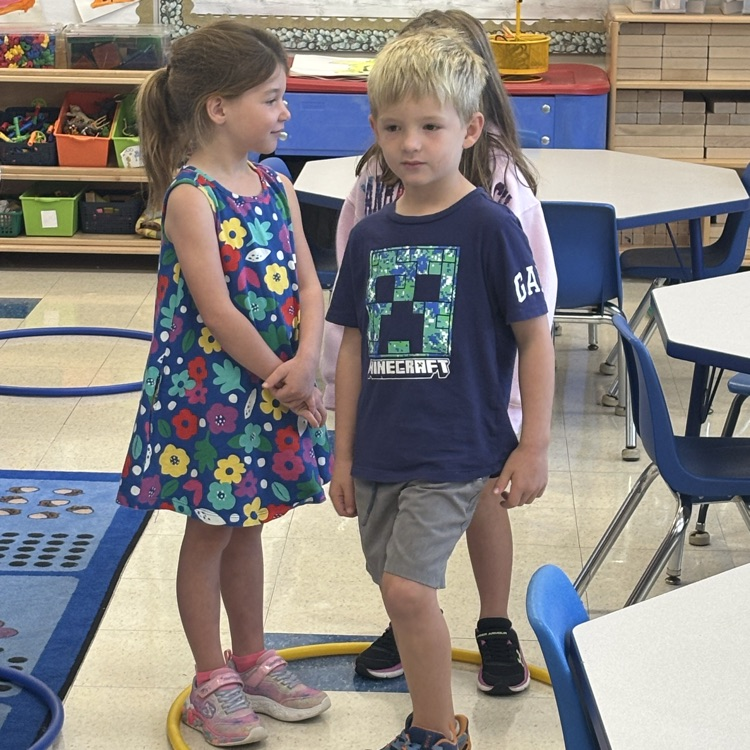 children standing on a hula hoop