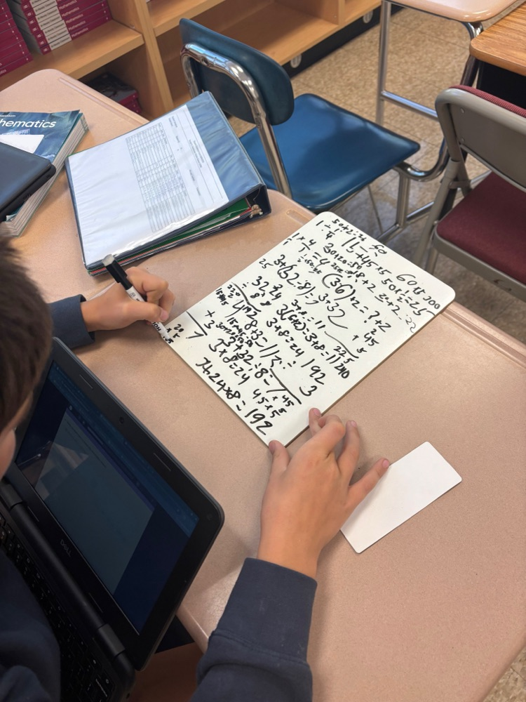 Student with white board working on math problems 