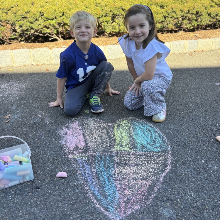 children drawing a heart with chalk