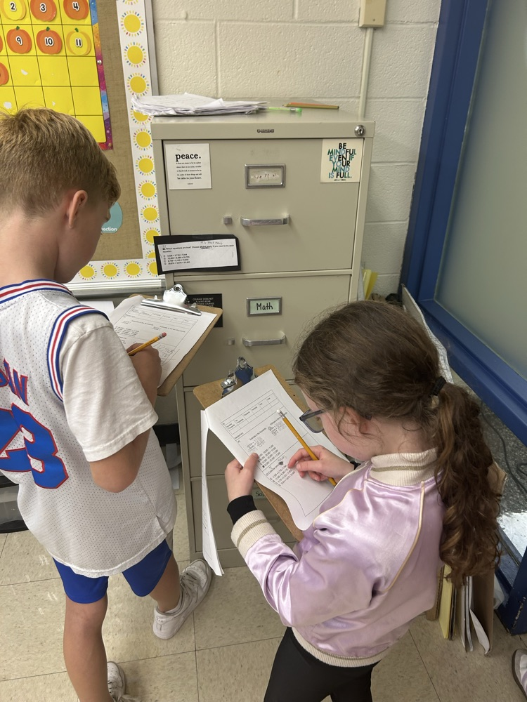 Students working around the room to solve math problems.