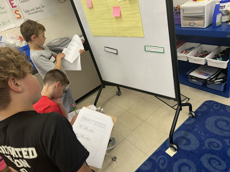 Students working around the room to solve math problems.