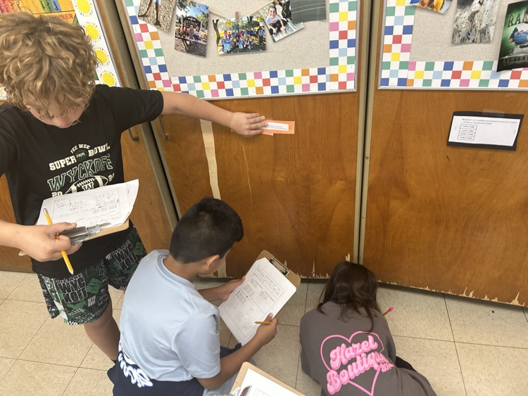 Students working around the room to solve math problems.