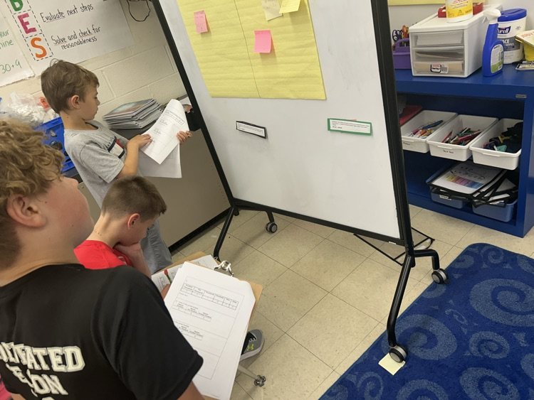 Students working around the room to solve math problems.