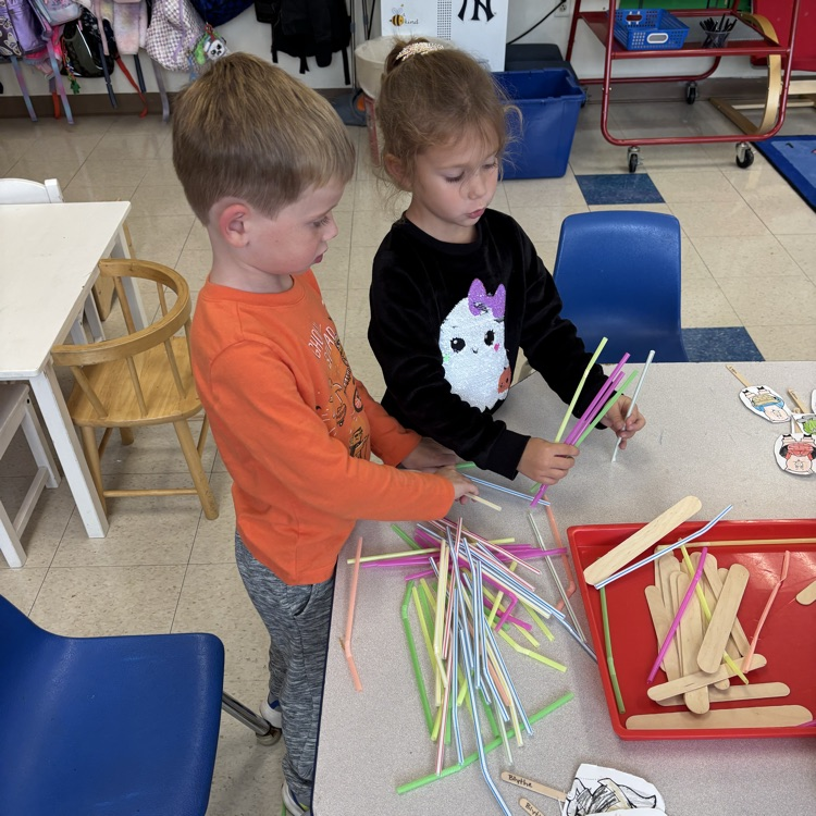 children working to build a house of straw