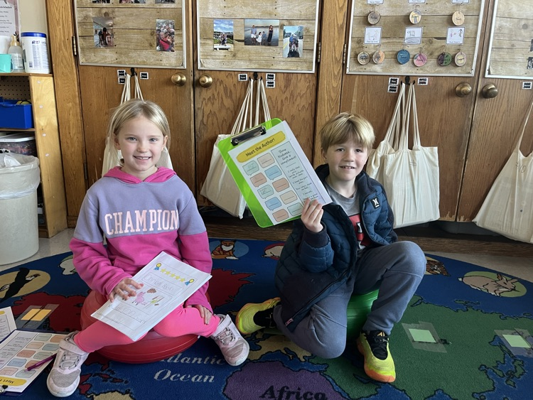 2 students sharing their writing together