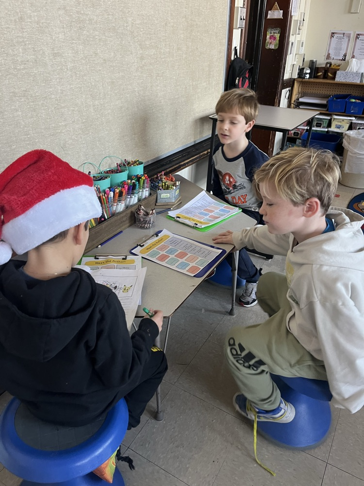 3 students sharing their writing together
