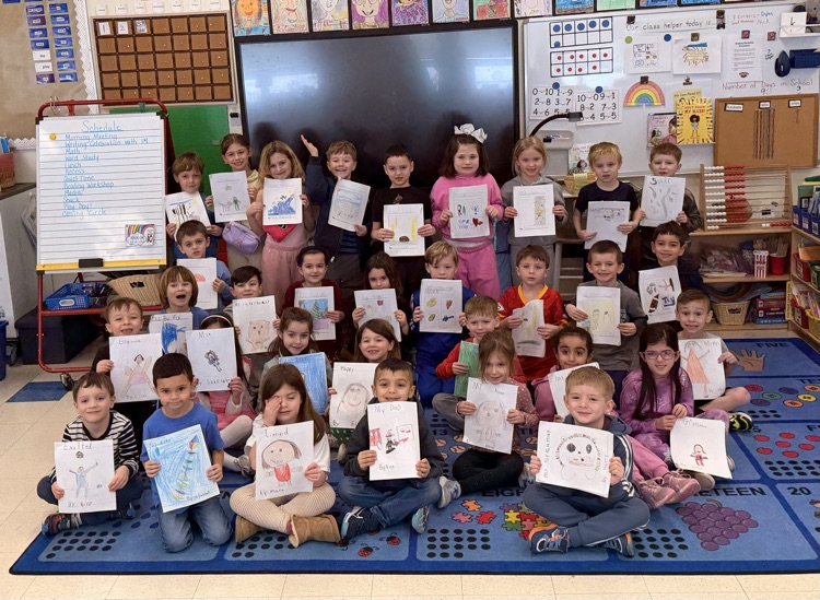 two full classes of students, smiling, and holding their books