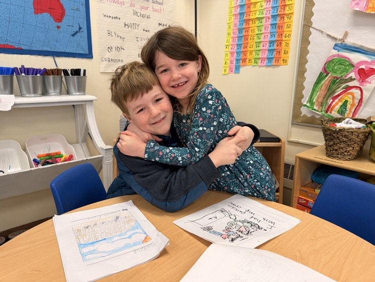 two students sharing their writing books together
