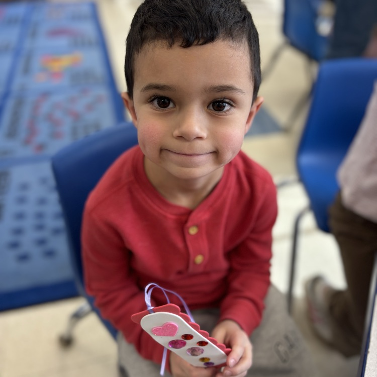 Little boy holding Valentine bookmark