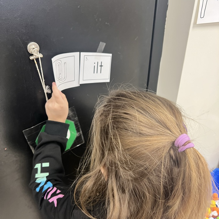 KRO uses QU to form words during a Write the Room activity 