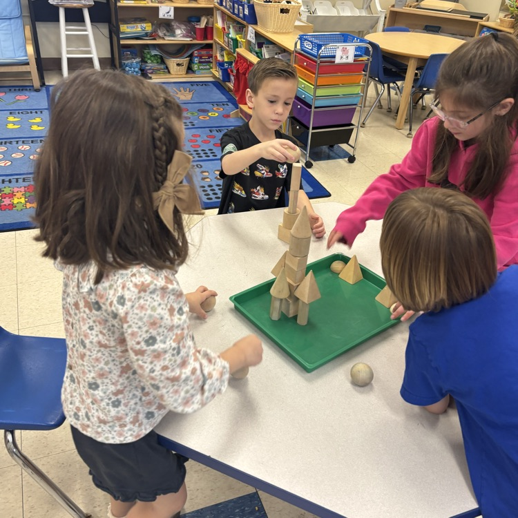 students working together to make a castle from solid shapes