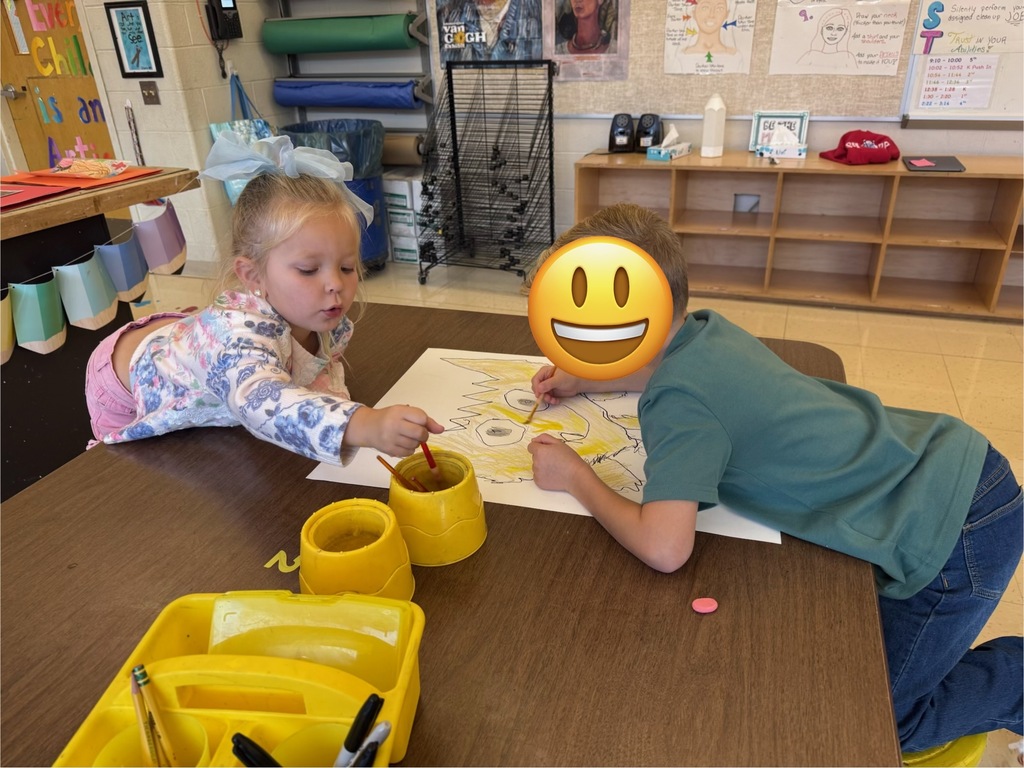 Two students painting together in the art room.