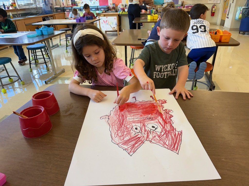 Two students painting together in the art room.