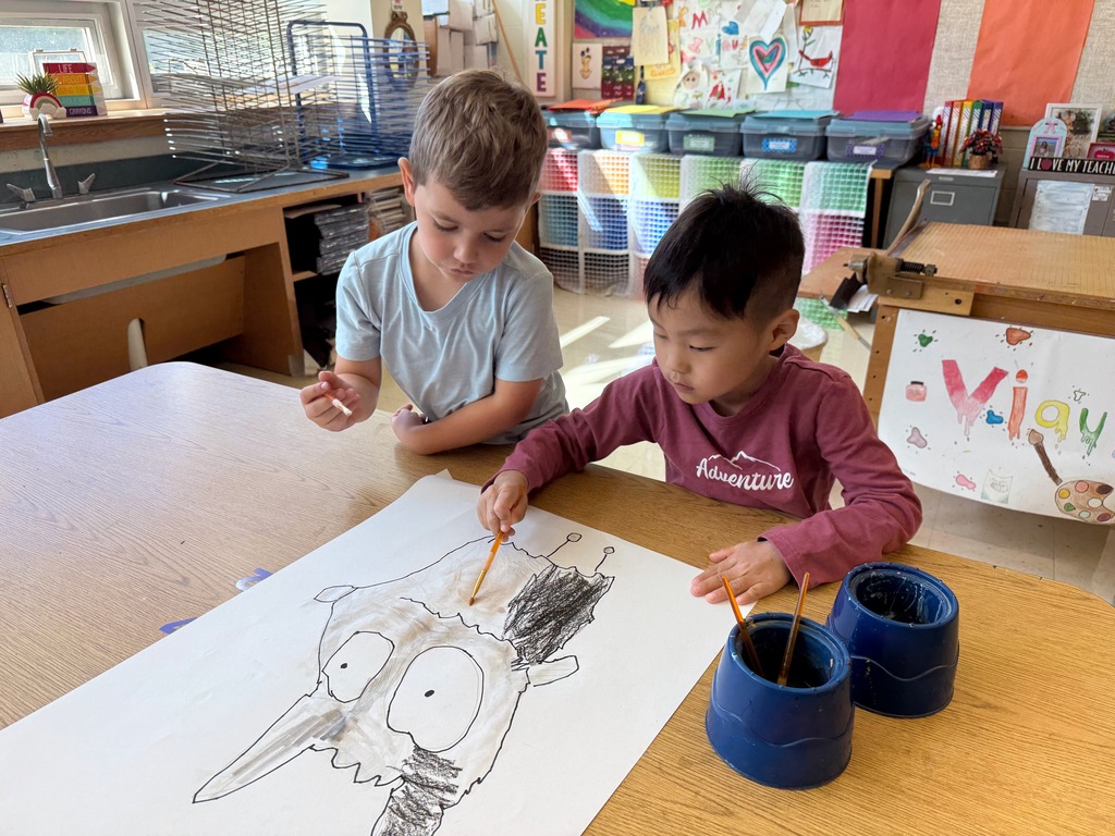 Two students painting together in the art room.